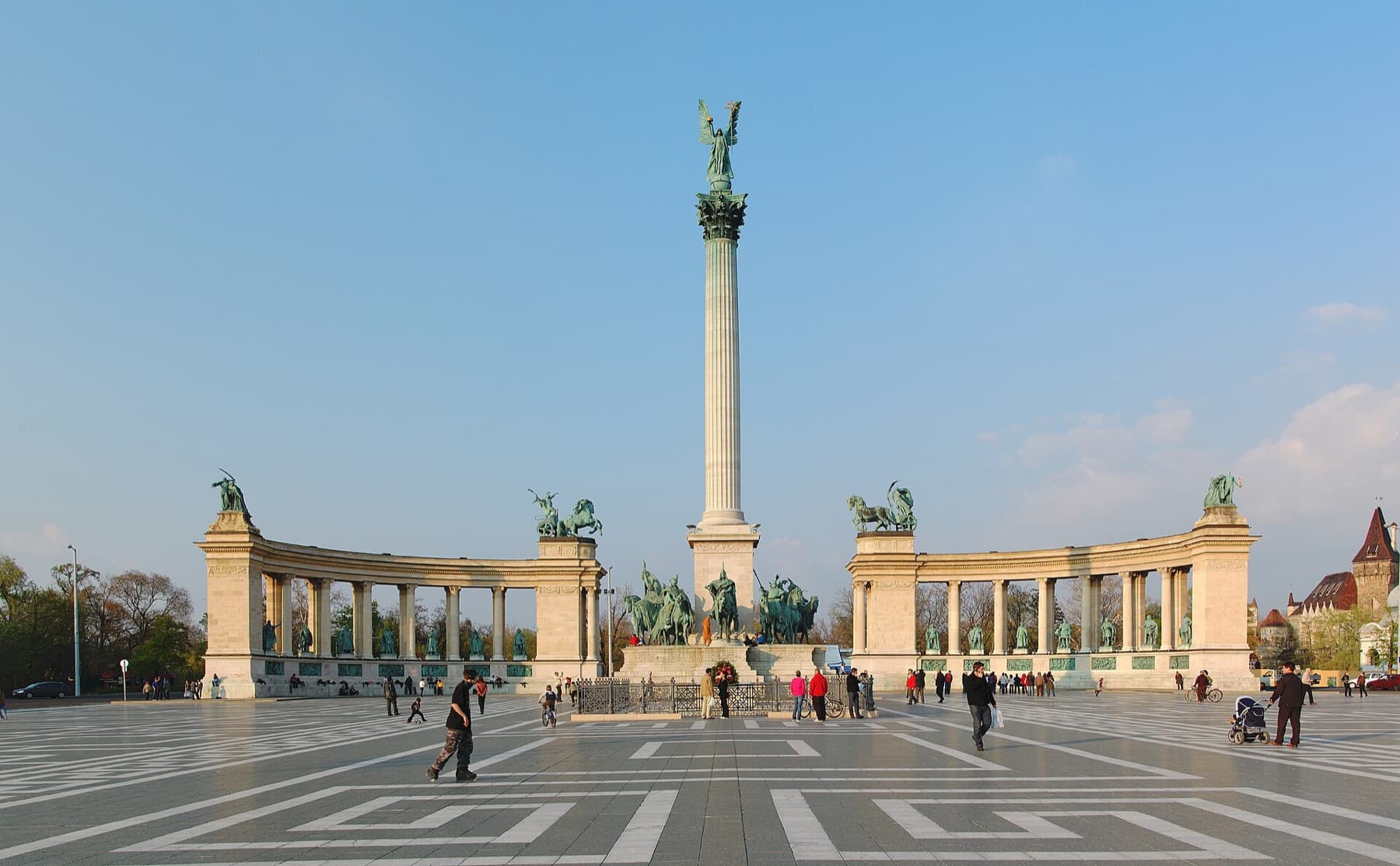 Het Heldenplein met de Millenniumzuil, de halfronde zuilengalerijen met standbeelden en wandelaars op het geplaveide plein
