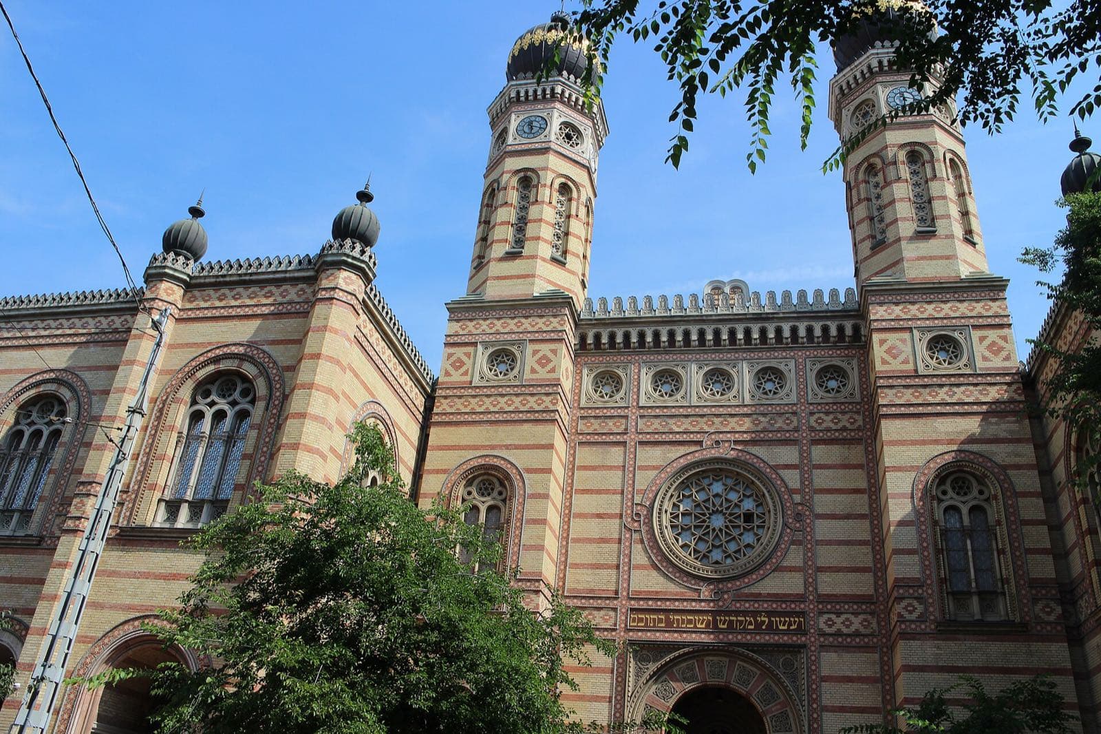 De gevel van de Dohány-synagoge in rood-gele baksteen met twee torens met uivormige koepels en een roosvenster